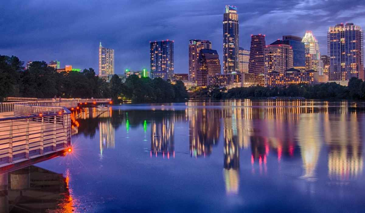 The downtown skyline of Austin, Texas reflecting on the lake at night. 