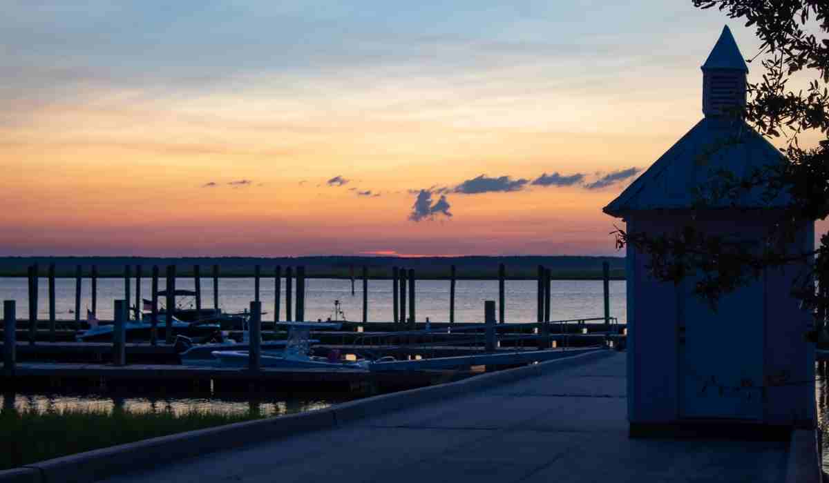 A pier at night during the sunset in South Carolina with blue and orange sky. 