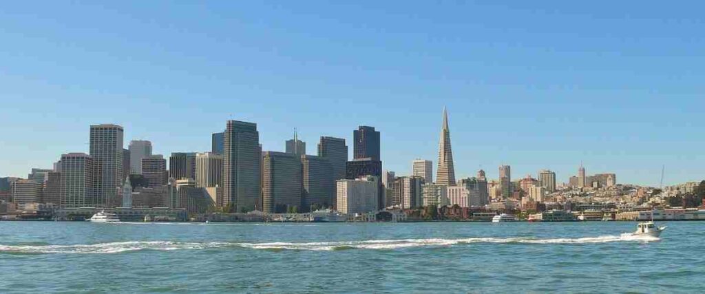 View of The Embarcadero from the ocean with  speed boat and skyline in the background. 